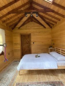a bedroom with a large bed in a wooden room at House Nero in Tonya