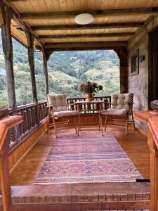 un porche con 2 sillas y una alfombra en el balcón en House Nero, en Tonya