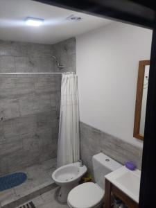a bathroom with a toilet and a sink and a shower at Malula Departamentos. in Playas Doradas