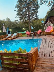 a swimming pool with a wooden deck and a table and chairs at Sıcak havuzlu dağ evi in Sapanca