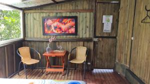 a porch with a table and two chairs and a tv at Sukha Glamping in Rionegro