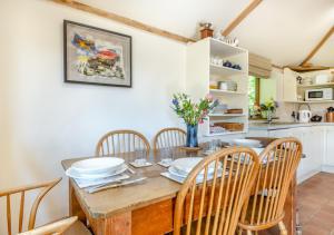 een keuken en eetkamer met een houten tafel en stoelen bij Shepherds Watch in Saint James