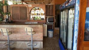 a bar with two stools in front of a brick wall at Pelekanos Apartments in Pissouri