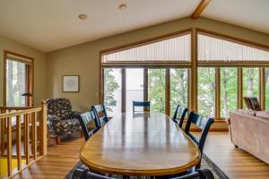 a dining room with a wooden table and chairs at Lakefront Home with Beach, Deck and Fire Pit! in Alexandria