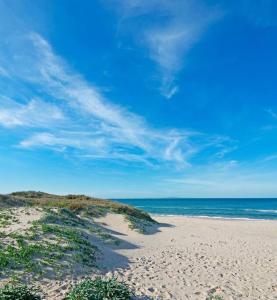 a sandy beach with the ocean in the background at Casa al mare in Sardegna in Platamona