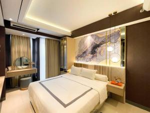 a bedroom with a large bed and a painting on the wall at Modern Cozy La Casa VI at Benson Tower in Surabaya +15 photos