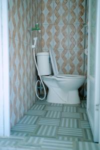 a bathroom with a white toilet in a room at Getrudis Guesthouse in Labuan Bajo