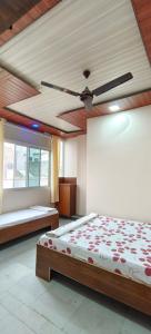 1 dormitorio con 2 camas y ventilador de techo en HOTEL ANJALI en Ujjain