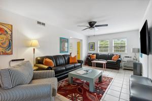 a living room with couches and a tv at Folly Vacation Great Location, Vintage and Fun 120 Unit A in Folly Beach