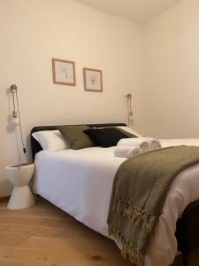 um quarto com uma grande cama branca e um candeeiro em La Casetta em Carrù