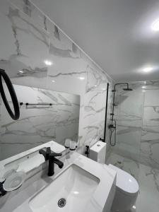 a white bathroom with a sink and a toilet at Rashed Luxury Camp in Wadi Rum