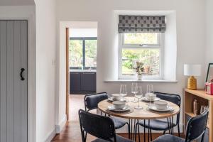 una sala da pranzo con tavolo, sedie e finestra di 59 Windermere Road, Kendal a Kendal