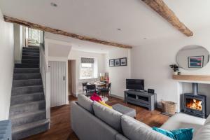a living room with a couch and a fireplace at 59 Windermere Road, Kendal in Kendal