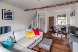 a living room with a gray couch with colorful pillows at 59 Windermere Road, Kendal in Kendal