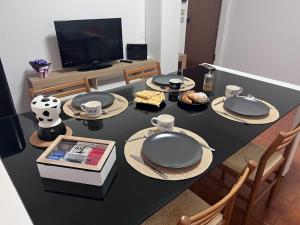 mesa de comedor con platos y TV en HOUSE DAMA, en Arenzano