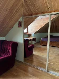 a living room with a couch and a bed in an attic at Vabaduse Guesthouse in Narva-Jõesuu