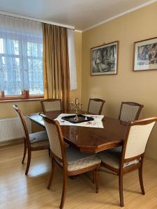 uma sala de jantar com uma mesa de madeira e cadeiras em Vabaduse Guesthouse em Narva-Jõesuu
