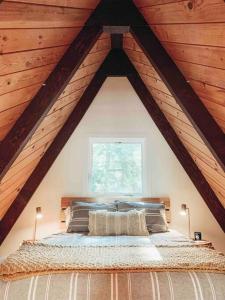 ein Schlafzimmer mit einem großen Bett im Dachgeschoss in der Unterkunft Mid Century Modern Cabin - The Tahoe A-Frame in Homewood