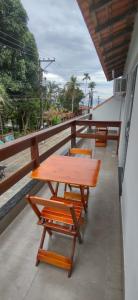 y balcón con mesa y sillas de madera. en Residencial 101 Ilha Grande, en Abraão