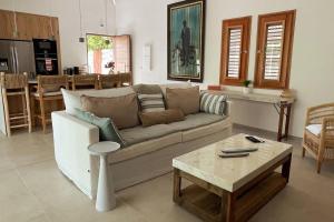 东方湾Orient Bay Villa Edenly的客厅里有一张沙发和一张桌子。