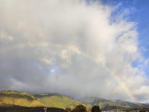 een regenboog in de lucht over sommige bergen bij Hotel Altamira Suites - Ibarra in Ibarra