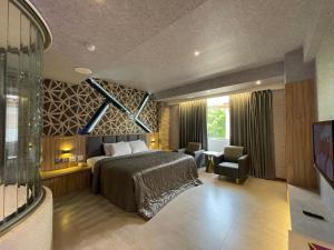 sypialnia z łóżkiem i krzesłem w pokoju w obiekcie King & Princess Motel - Rende w mieście Rende