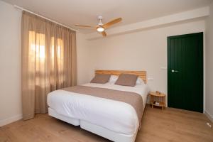 1 dormitorio con cama blanca y puerta verde en Paradisun Villajoyosa, en Villajoyosa