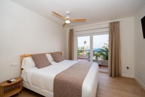 a bedroom with a bed and a window with a balcony at Paradisun Villajoyosa in Villajoyosa