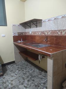 a kitchen with a sink and a tile floor at DonnaSabi in Tingo María