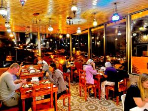 瓦迪穆薩的住宿－Petra Desert Dream Hotel，一群坐在餐厅桌子上的人