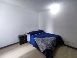 a bedroom with a blue bed in a white room at Apartamento con piscina, frente a CC Mayorca in Sabaneta +14 photos