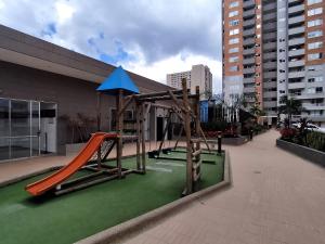 a playground with a slide on a greenlevard at Apartamento con piscina, frente a CC Mayorca in Sabaneta