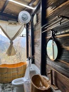 a bathroom with a toilet and a window at Mando Homestay in Bắc Yên