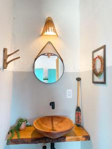 y baño con lavabo de madera y espejo. en Caiana loft Cumuruxatiba en Cumuruxatiba