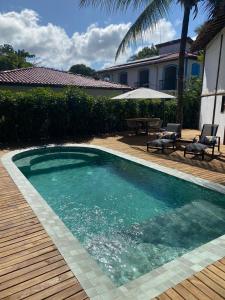 a swimming pool with a table and chairs next to a house at Pousada Bambu Dourado in Marau