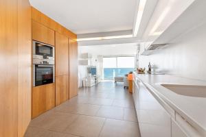 a white kitchen with a view of the ocean at Luxury First Line Apartment. in Salinetas