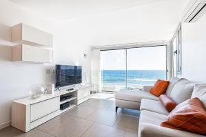 a living room with a white couch and a large window at Luxury First Line Apartment. in Salinetas