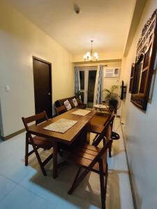 a dining table and chairs in a living room at The Verdin at Maple Grove in Cavite