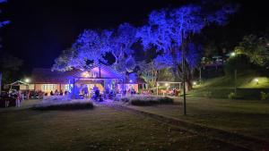 a group of people standing in front of a building with blue lights at Hotel Solar Fazenda Do Cedro in Itaipava