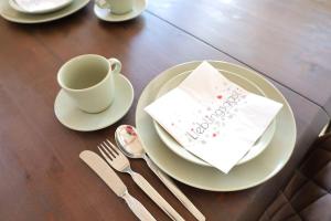 un tavolo con una tazza e un piatto con un tovagliolo di Ferienwohnung Heimbach Burgblick a Heimbach Altre 3 foto
