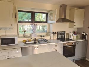 a kitchen with white cabinets and a counter top at The Aul Shop & Public House -entire private annexe 