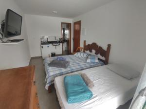 a bedroom with two beds and a tv at Residencial 101 Ilha Grande in Abraão