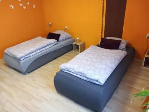 格里馬的住宿－Ferienwohnung Linke "Holzblick"，橙色墙壁客房的两张床