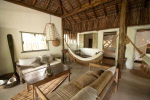 1 dormitorio y sala de estar con hamaca. en Casa Mar Pé na Areia, en Caraíva