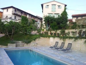 una piscina con due sedie accanto a un edificio di Boutique Hotel Dvor a Dobrovo