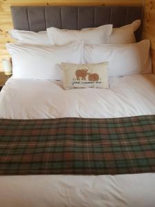 Una cama blanca con una almohada encima. en Dunbeath Coastal Retreat, en Dunbeath