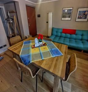 a living room with a wooden table and a blue couch at PUNTA VITTORIA SUB 14 - RESIDENCE ANDERBATT GRESSONEY - 3 locali - CIR N 0010 in Staval