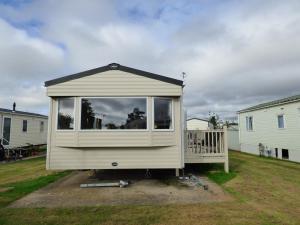 a tiny house with a large window in a yard at Orchards 29 at Southview Leisure Park in Skegness