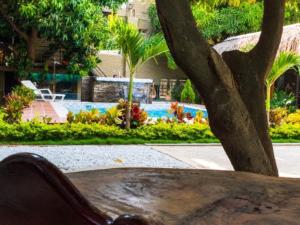 a table in front of a pool with a tree at Hostal Los Arhuacos in Santa Marta
