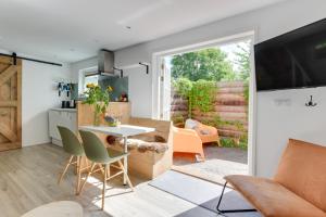 een keuken en een woonkamer met een tafel en stoelen bij The Forester Schoorl in Schoorl